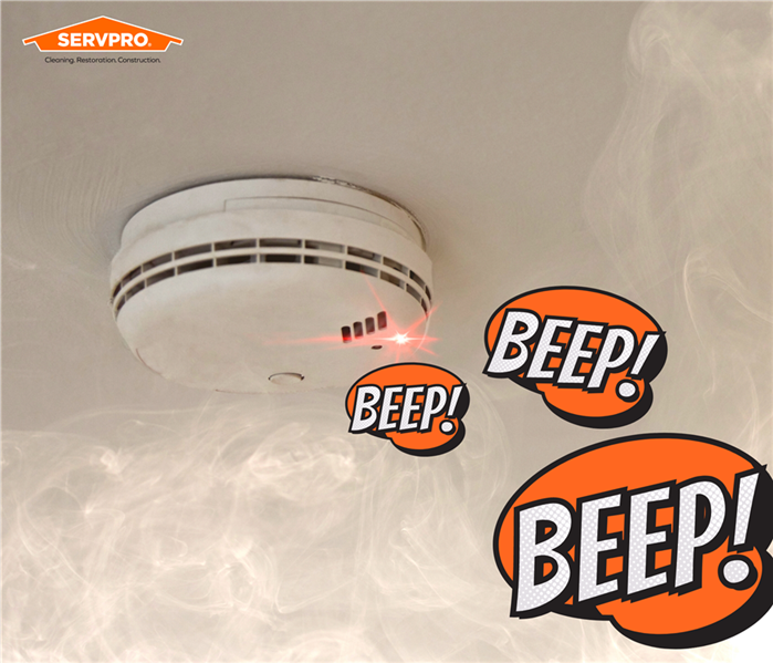 smoke alarm on ceiling, white, smoke from below, graphics of the word "beep" three times, servpro logo in corner